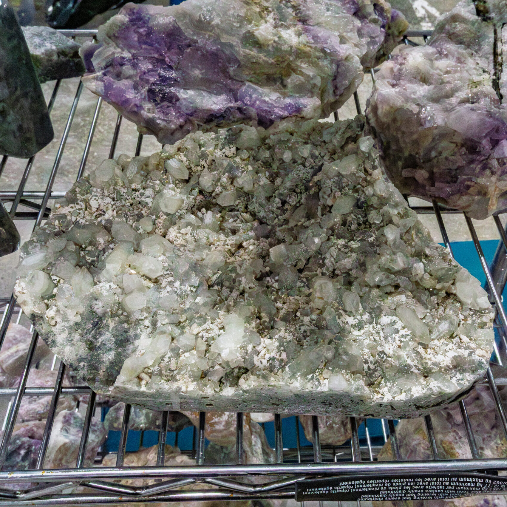 Large raw mineral cluster and amethyst formations on display at a Rock and Gem Expo