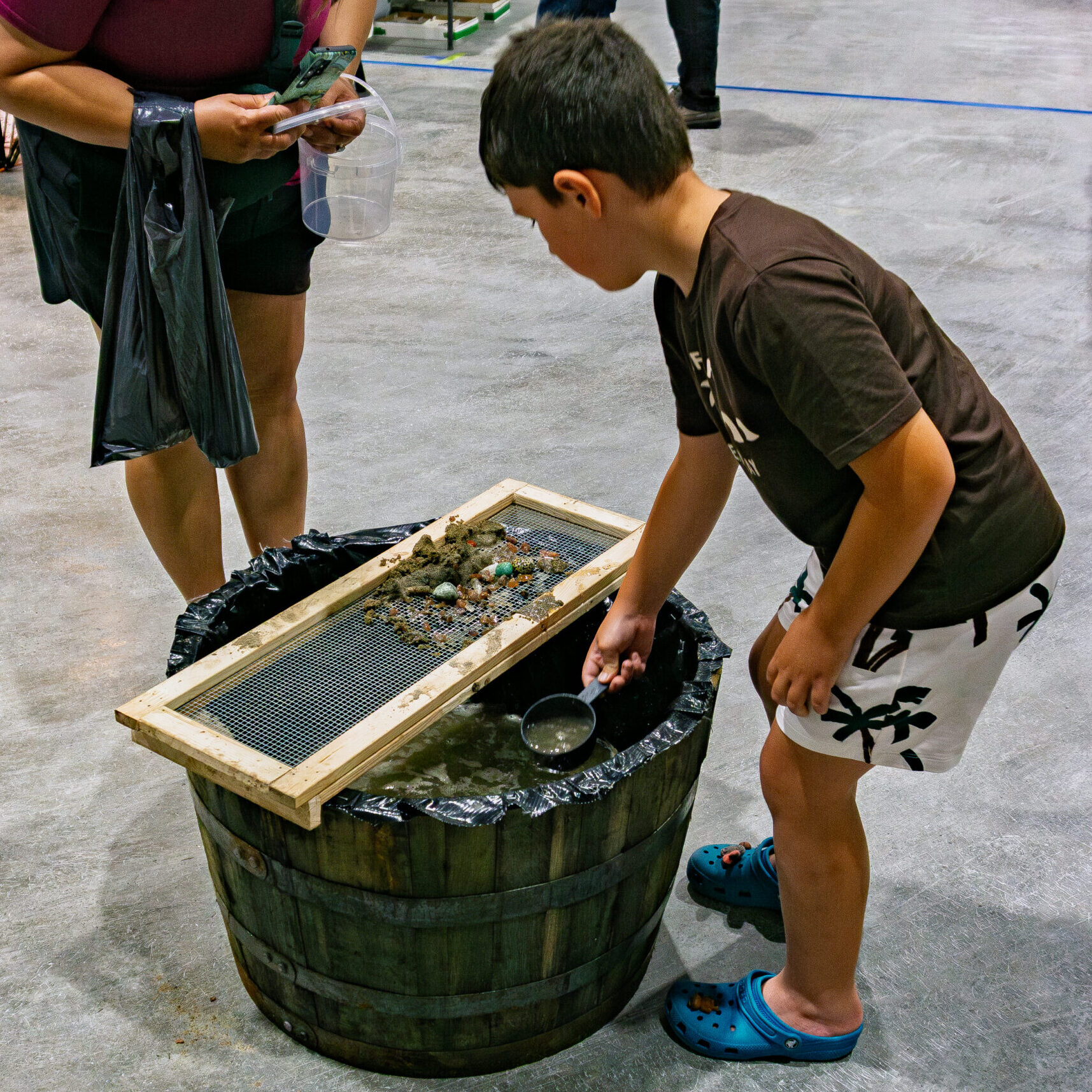 Child discovering gemstones at the Rock and Gem Expo gem sifting station in Kitchener